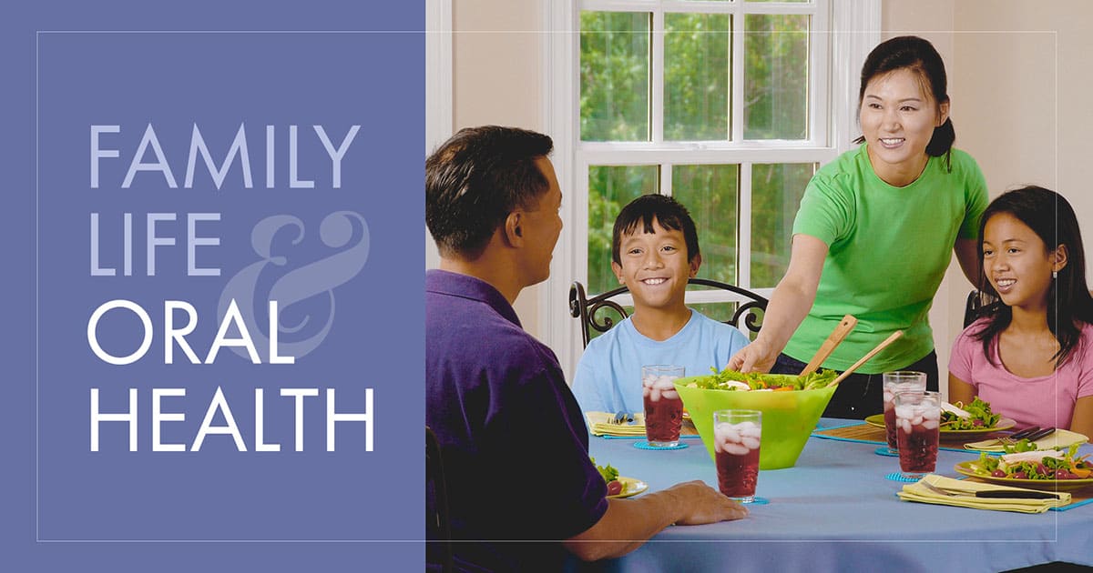 Family smiling with healthy teeth and eating a meal together